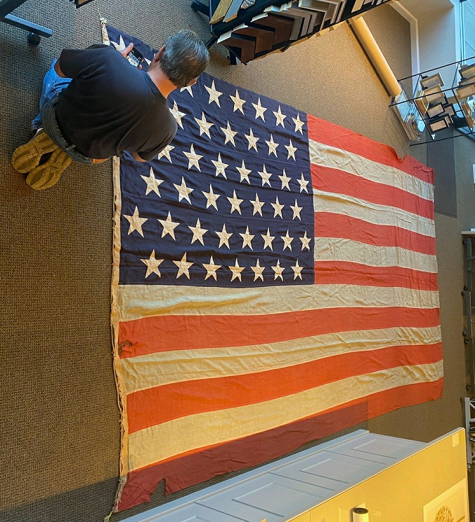 A RARE WORLD WAR II ISSUED LARGE-SIZE & I'D 48-STAR AMERICAN FLAG, FLOWN ON THE TRANSPORT SHIP 